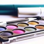 Close-up of colorful eyeshadow palette with brush, ideal for fashion and beauty themes.